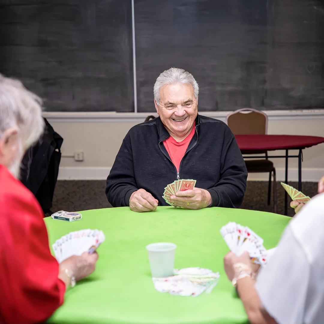 Smiling man playing cards at table