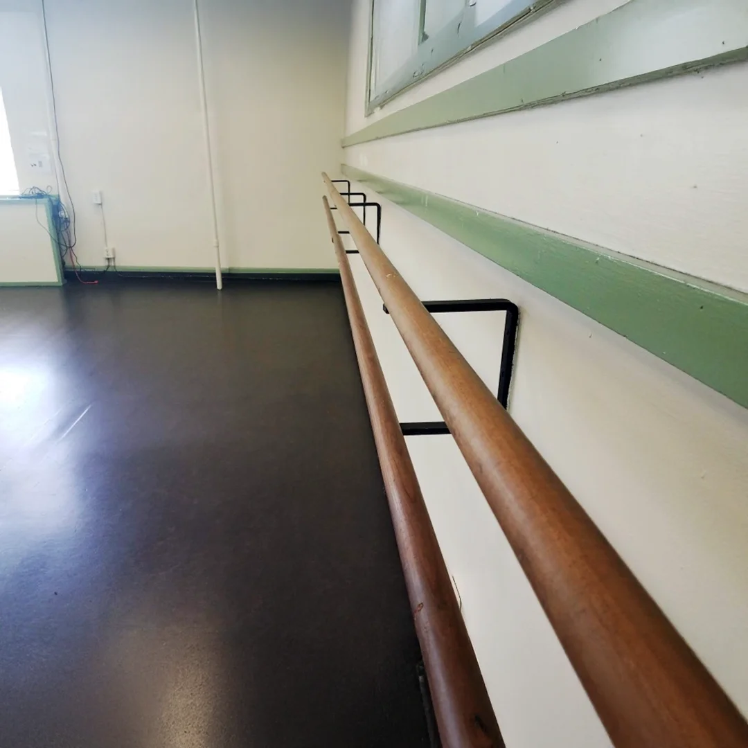 Wooden ballet bar in empty studio