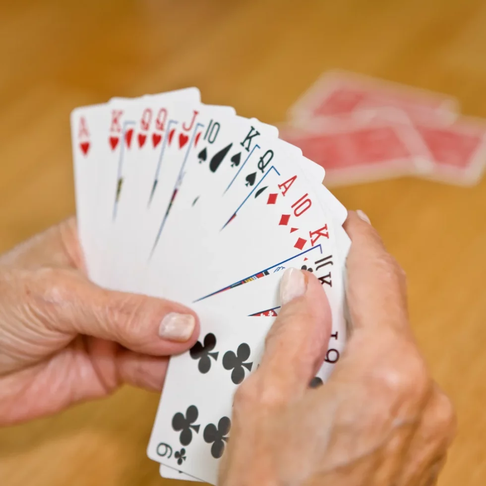 Hands holding a fanned deck of cards