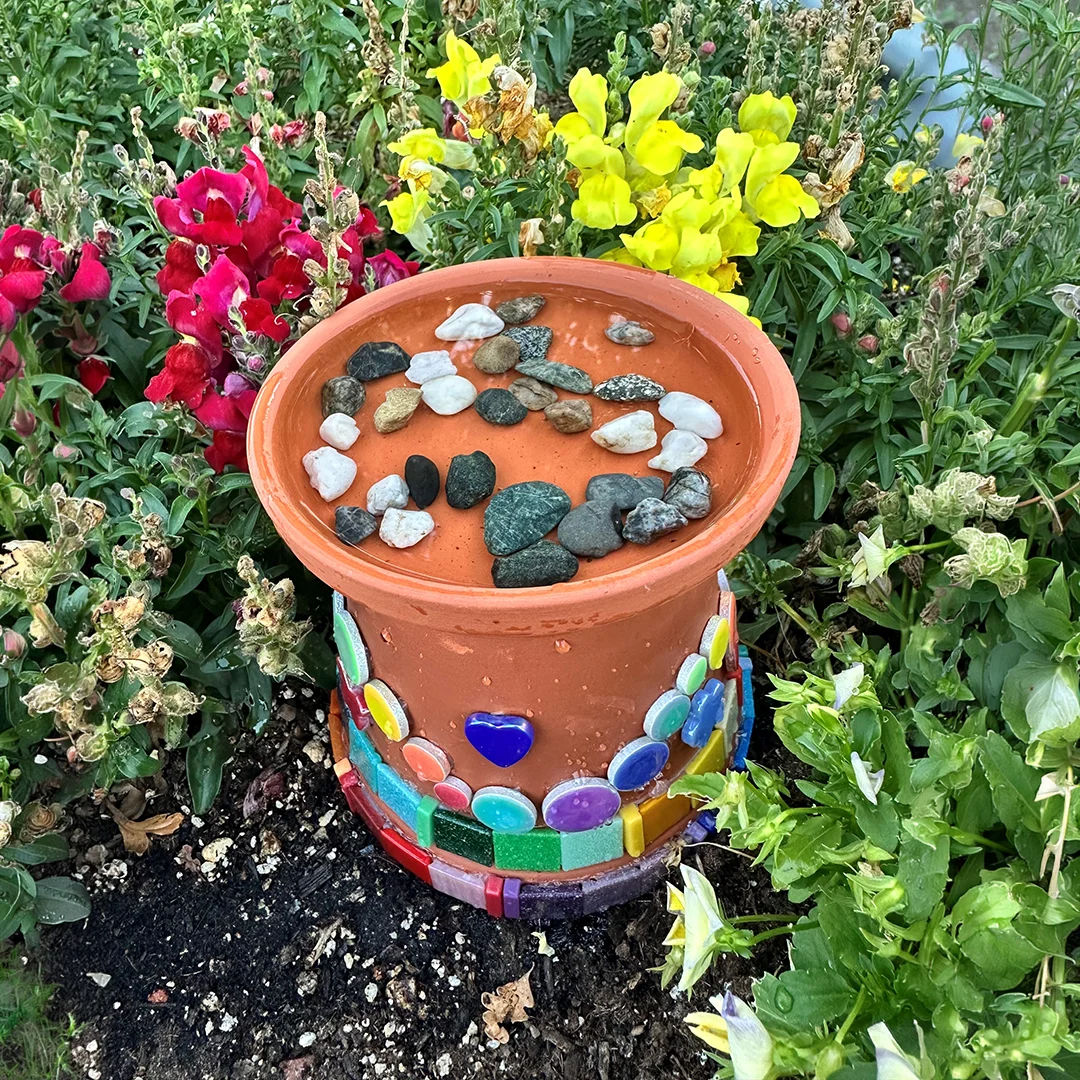 Colorful pot with stones and flowers